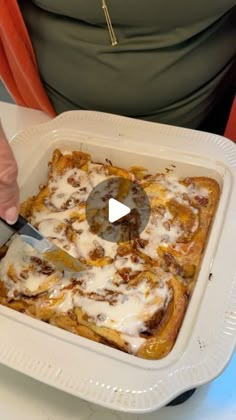 a person cutting into a casserole dish with a knife