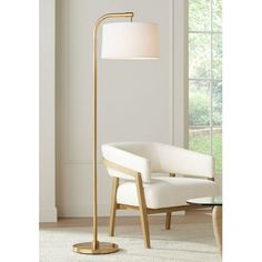 a modern floor lamp with a white shade on the base and a gold metal arm