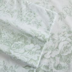 an image of a bed sheet that has flowers on it in green and white colors