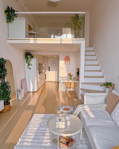 a living room filled with furniture and a staircase leading up to the second floor above