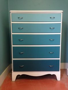 a blue and white chest of drawers in a room