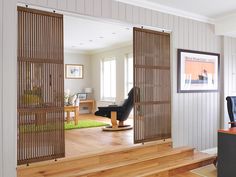 an open door leading to a living room with a computer desk and chair in it