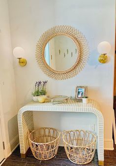 a white table with two baskets under a mirror