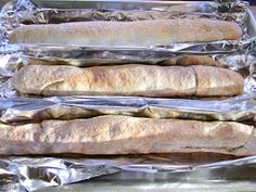 four long loafs of bread wrapped in aluminum foil