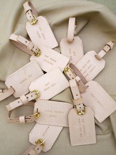 several white luggage tags with gold hardware on them