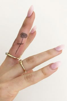 a woman's hand with a small tattoo on it, holding up her finger