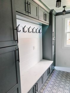 the inside of a kitchen with gray cabinets and white counter tops