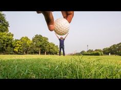 a person holding up a golf ball in the air