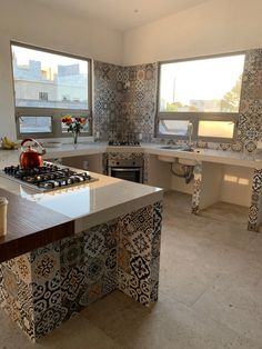 a kitchen with an island, stove top and sink in it's center area