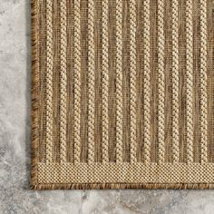 a close up of a rug on a floor with marble floors and walls in the background