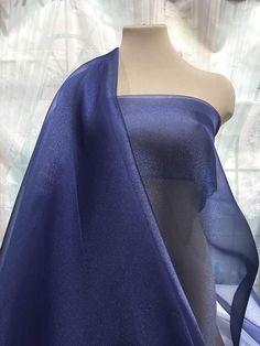 a mannequin with a blue dress on it's head and one piece of fabric draped over the top