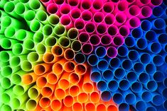 many different colored tubes stacked together in the shape of a rainbow wallpaper, colorful walls,