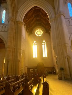 the inside of a church with pews and stained glass windows