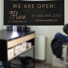 we are open hair by annabelle sign hanging from the ceiling in an office