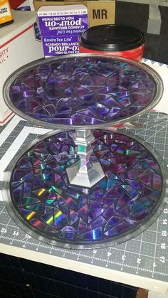 two trays that have been made out of cds and are sitting on a table