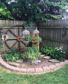 an outdoor garden with lots of flowers and plants in the center, along side a fence