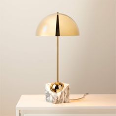 a lamp that is sitting on top of a white table next to a light bulb