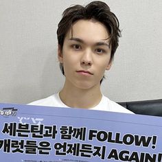 a young man holding up a sign with the words follow written in korean on it