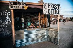 an old post office that has been vandalized with posters and writing on it