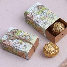 two boxes with chocolates in them sitting on a table next to a small map