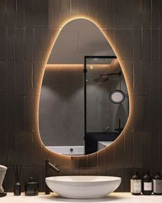 a bathroom with a sink, mirror and lights on the wall above it's counter