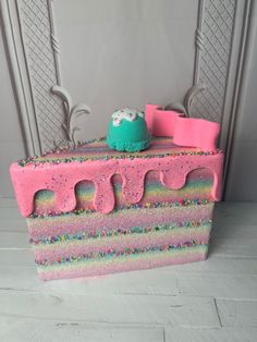 there is a cake made to look like it has pink frosting and sprinkles