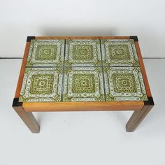 a wooden table with green and white tiles on it