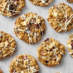 cookies with white icing and cranberries on a marble counter top, ready to be eaten