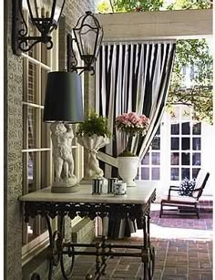 an entry way with a lamp and vases on the table