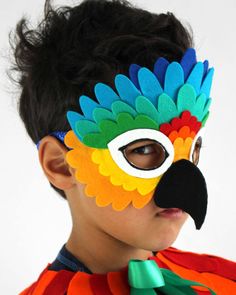 a young boy wearing a colorful parrot mask on top of his head and black nose