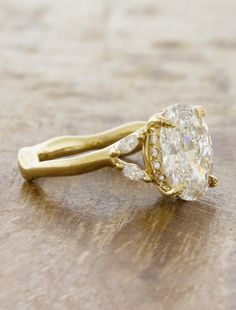 a yellow gold ring with an oval cut diamond