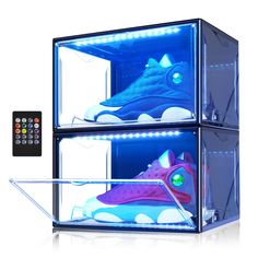 a pair of shoes are in a display case with remotes on the side and an image of a shark inside