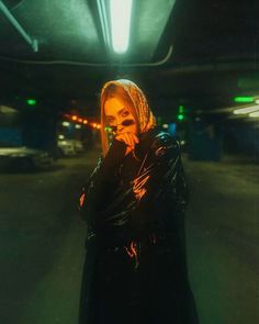 a woman standing in the middle of an empty parking garage with her hands on her face