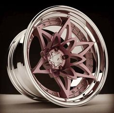 a wheel with pink spokes and diamond accents on the rim is shown in this image