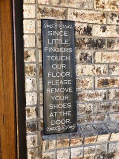 a sign on the side of a brick building that says, since little fingers touch our floor please remove your shoes at the door