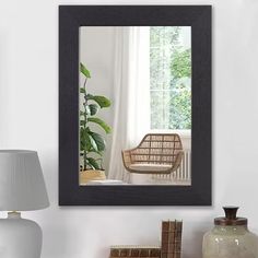 a chair sitting next to a window in a room with white walls and a lamp