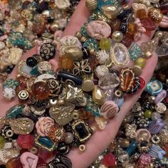 a person's hand is full of assorted beads