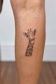 a small giraffe tattoo on the leg