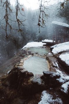 a hot tub surrounded by snow covered rocks