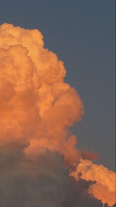 an airplane is flying in the sky at sunset or dawn with clouds and orange hues