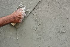 a man is plastering the wall with his hand