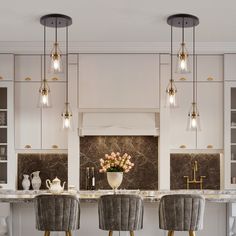 an elegant kitchen with marble counter tops and bar stools