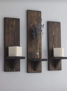 three wooden wall shelves with candles on them