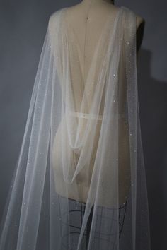 a mannequin wearing a white veil with sequins on it