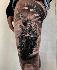 a man's leg with a motorcycle tattoo on it and speedometer in the background