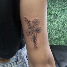 a woman's arm with a flower tattoo on the left side of her arm