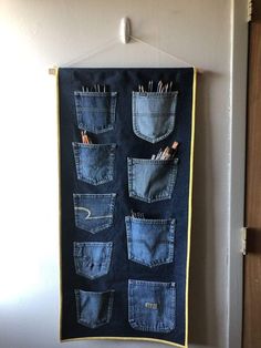 an old pair of jeans hanging on a wall with pencils and pens in them