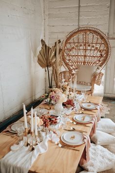 a long table with plates and candles on it