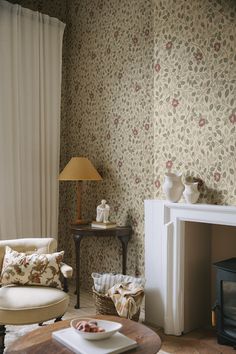 a living room filled with furniture and a fire place in front of a wallpapered wall