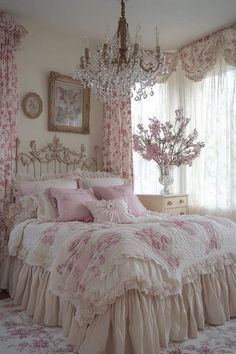 a bedroom with pink and white bedding, chandelier, window curtains and flowers